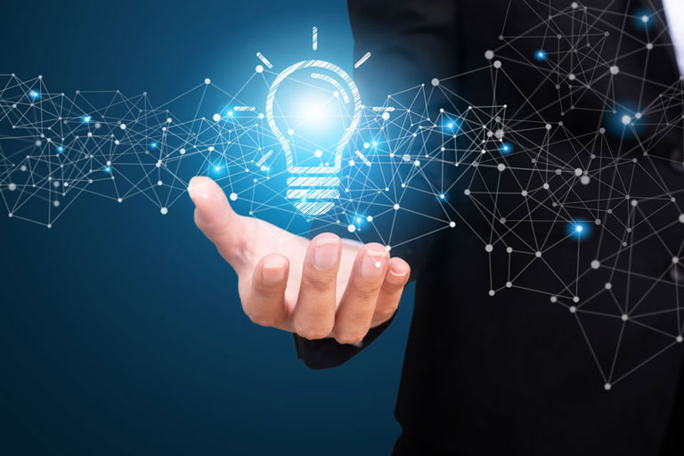 An outstretched hand holding an intangible lightbulb creating